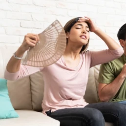 woman waving herself with fan